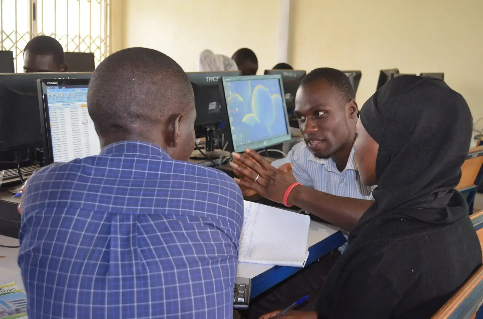 Young people working together at computers during an ICT workshop